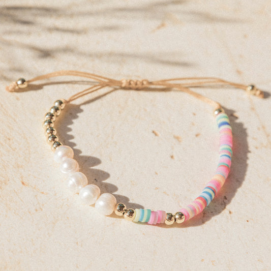Armband mit bunten Lehmperlen, echten Süßwasserperlen und goldfarbenen Details auf beigefarbenem Zugband – Pearl Vibes von Wild Tides