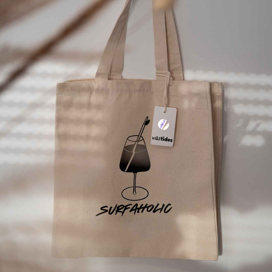 vorderseite Jute Strandtasche mit Motiv von einem Weinglas mit Surfboard als Strohhalm- unten drunter ist der Schriftzug Surfaholic aufgedruckt