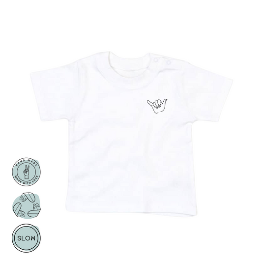 Vorderseite des Babyshirts mit Shaka-Hand-Symbol in Schwarz
