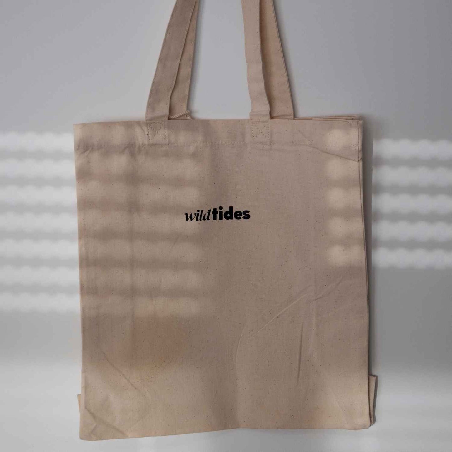 Rückseite der Shaka Vibes Stofftasche mit schlichter Wild Tides Logoprint in Schwarz