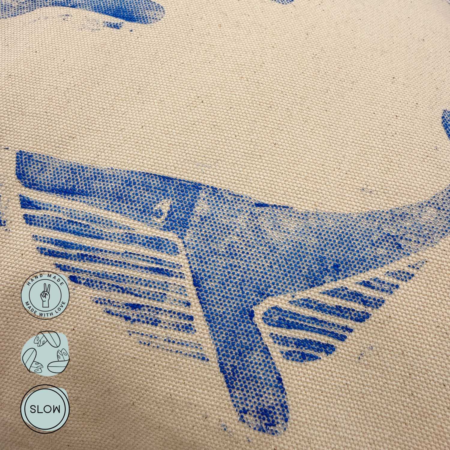 Detailaufnahme des handbedruckten Wal Musters in Blau auf naturfarbenem Kissenstoff